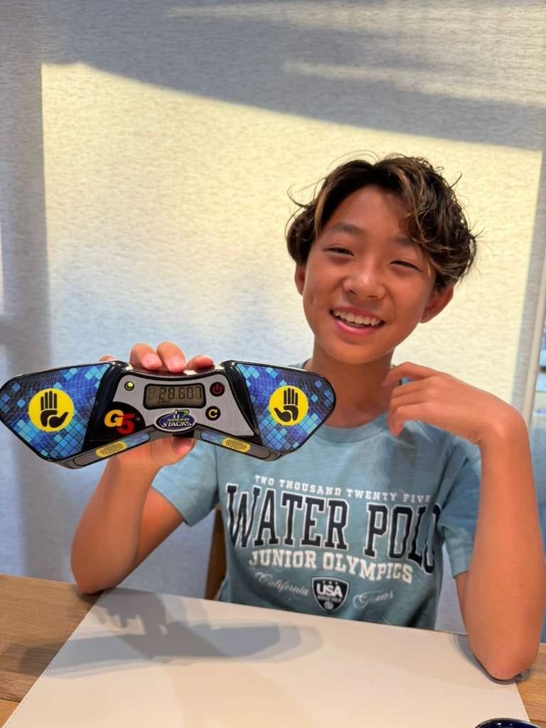 Young student celebrating sub-30 second solve on timer