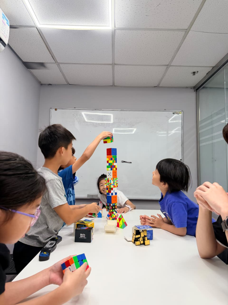 Kids building giant Rubik's cube tower together